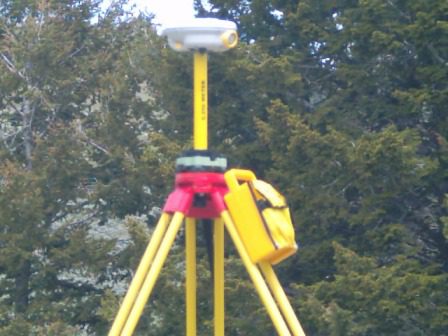 Surveying equipment set up outdoors on a tripod.