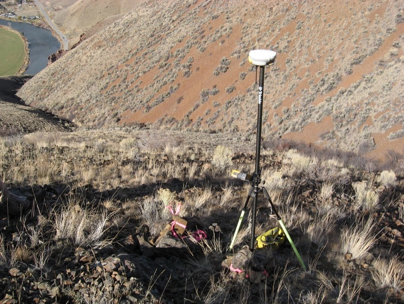 Section Retracement - Photo of Survey equipment on a grassy hillside.