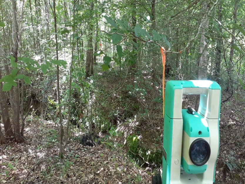 Boundary Traverse - Photo of Surveying equipment in a dense forest area.