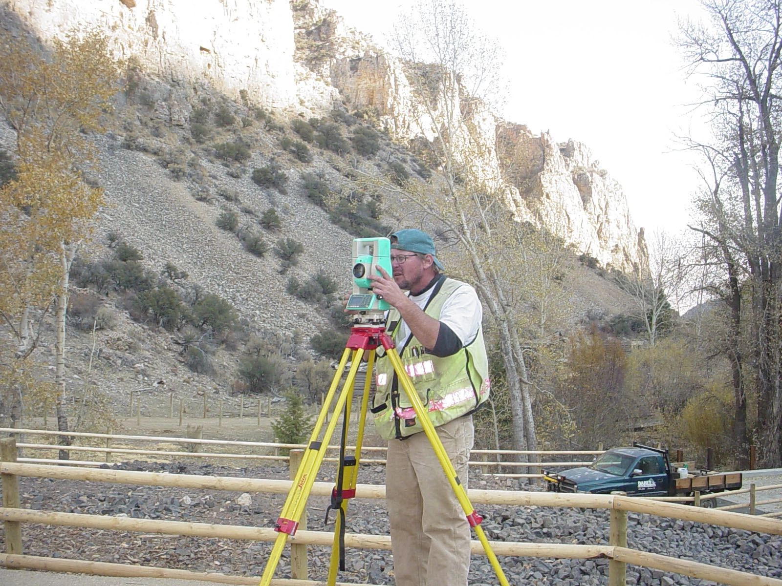 Surveyor using equipment in mountainous area.
